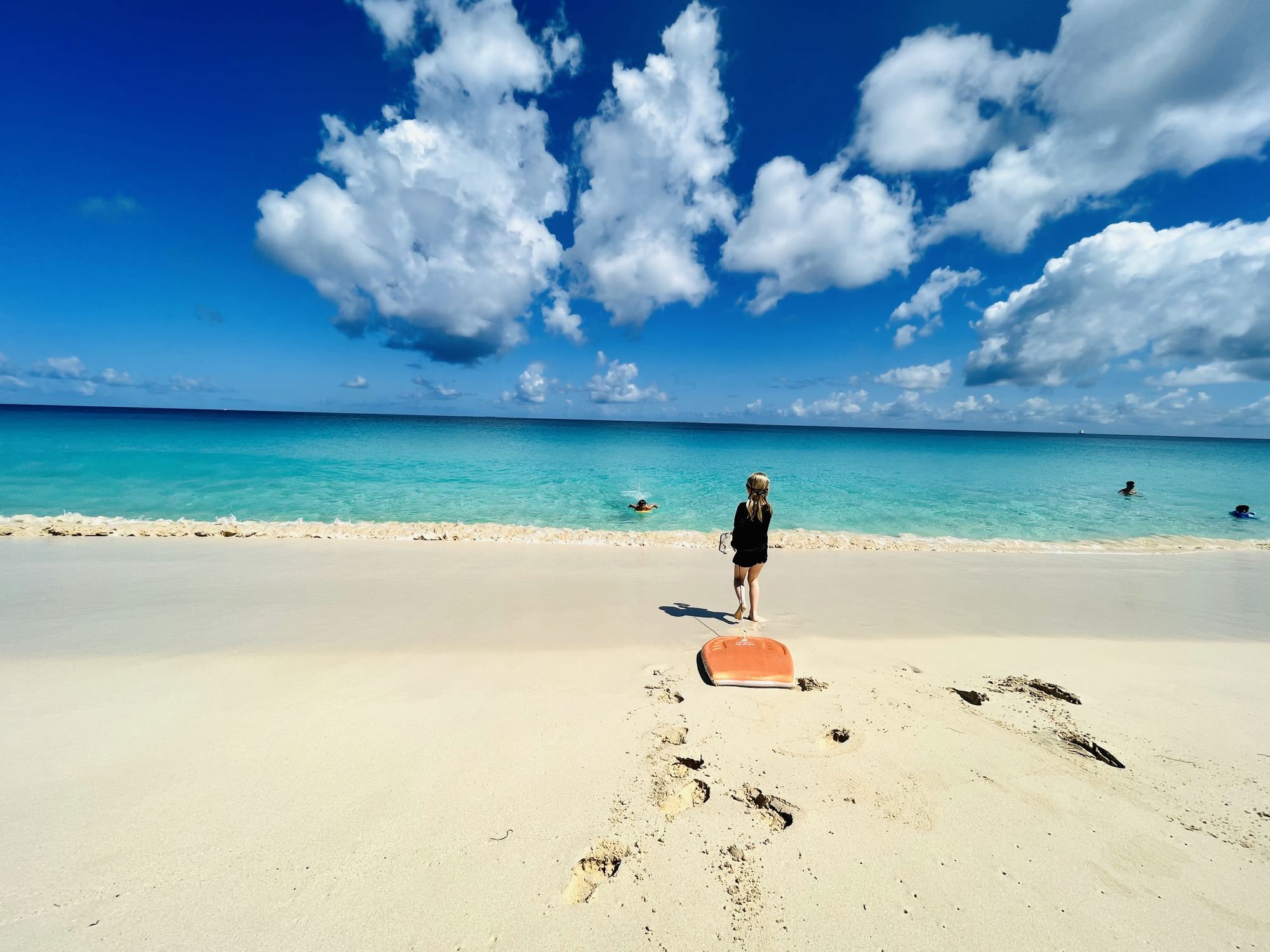 Our daughter with her bodyboard at the edge of the turquoise water in Anguilla